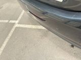 a black car parked in a parking lot with a sticker on it