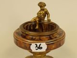 an antique brass plate with a figurine on top of it