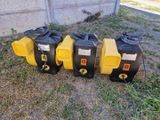 three yellow and black blowers sitting on the ground next to each other