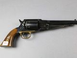 a close up of a revolver with a wooden handle on a white surface