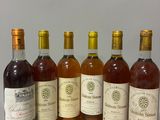 six bouteilles de vin sont alignées sur une table