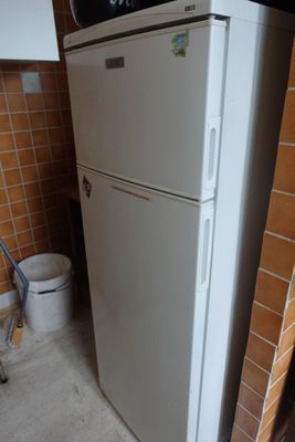un réfrigérateur blanc dans le coin d'une cuisine