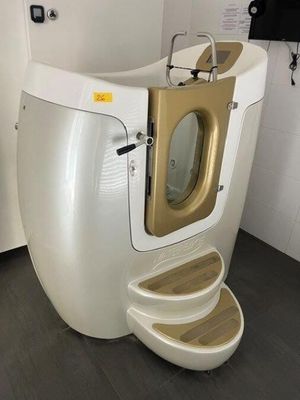 des toilettes blanches avec une porte dorée dans une salle de bains