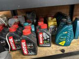 bottles of motor oil are lined up on a shelf in a garage