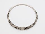 a close up of a silver bracelet on a white surface
