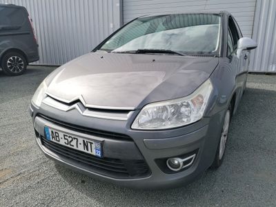 a small grey car parked in front of a building