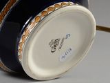 underside view of a blue and white vase with a gold rim