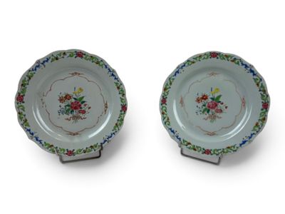 two plates with floral designs on them on a white surface