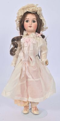 une poupée qui porte une robe blanche et un chapeau