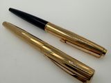 two pens sitting on top of each other on a table