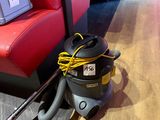 a vacuum that is sitting on the floor next to a couch