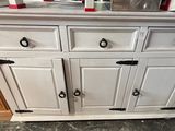 a white cabinet with red knobs on it in a kitchen
