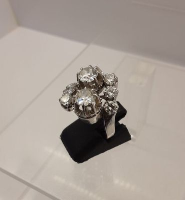 a close up of a diamond ring on a black stand