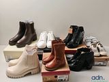 plusieurs paires de chaussures d'enfants posées sur des cartons, sur une table