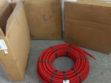 several boxes of red hoses sitting on the floor next to each other