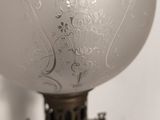 a lamp that has a white glass shade on it