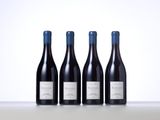 three bottles of wine are lined up on a table