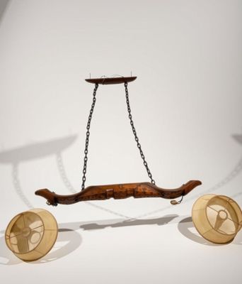 un objet en bois suspendu à une chaîne au mur