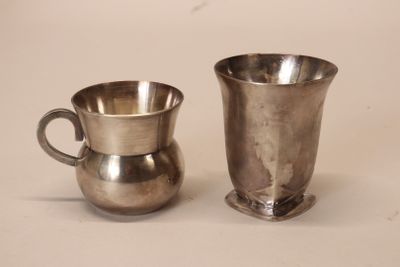 two silver cups sitting next to each other on a table