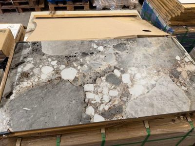 a large pile of marble on a pallet in a warehouse