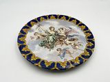 a blue and gold plate with a painting on it