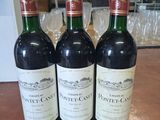 trois bouteilles de vin posées sur une table en bois