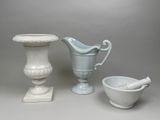 trois vases, un bol et un mortier posés sur une table