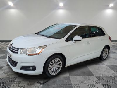 une voiture blanche est garée dans une pièce au sol à carreaux