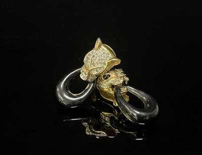 un gros plan d'une bague en or et en argent sur une surface noire
