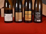 several bottles of wine are lined up on a red cloth