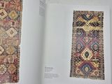 an open book with a picture of two rugs on a table