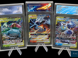 quatre cartes Pokémon différentes dans des pochettes en plastique, sur fond noir