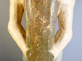 une statue représentant un homme tenant un vase posé sur une table
