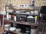 a kitchen with a stove, microwave, dishwasher, and other items on a shelf