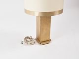 gold metal table lamp with a white shade and a ring on the base