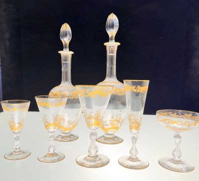 cinq verres à vin et une carafe posés sur une table