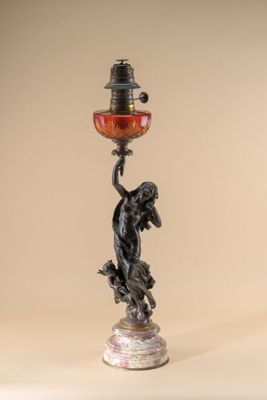 a statue of a woman holding a lamp on top of a table