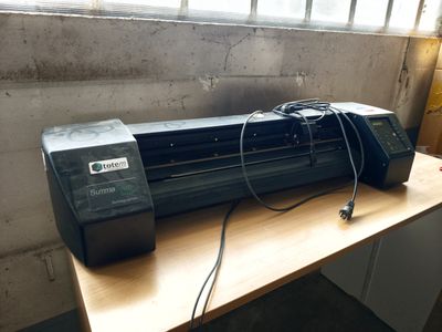 an image of a printer sitting on a desk in front of a window