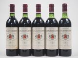 quatre bouteilles de vin rouge sont alignées sur une surface blanche