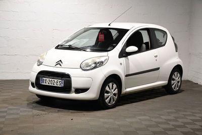une petite voiture blanche garée dans un garage