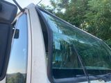 a white truck with a broken windshield and a mirror