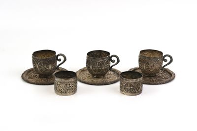 four antique silver cups and saucers on a white background