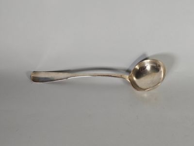 une cuillère en argent posée sur une surface blanche, d'où une autre cuillère dépasse sur le côté