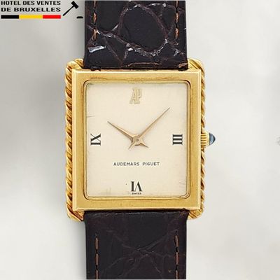 a gold watch with roman numerals on the face