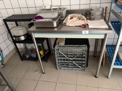 une cuisine équipée d'un évier et d'une table en métal