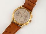 gros plan d'une montre sur une surface blanche avec un bracelet marron