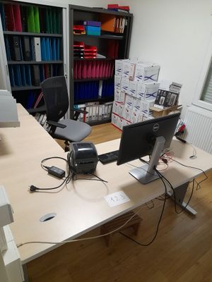 a desk with a computer monitor and a printer on it