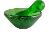 un bol en verre vert dans lequel se trouve une cuillère verte