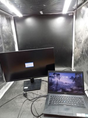 a laptop computer sitting next to a monitor in a room