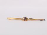 an image of a gold tie bar with a knot on it